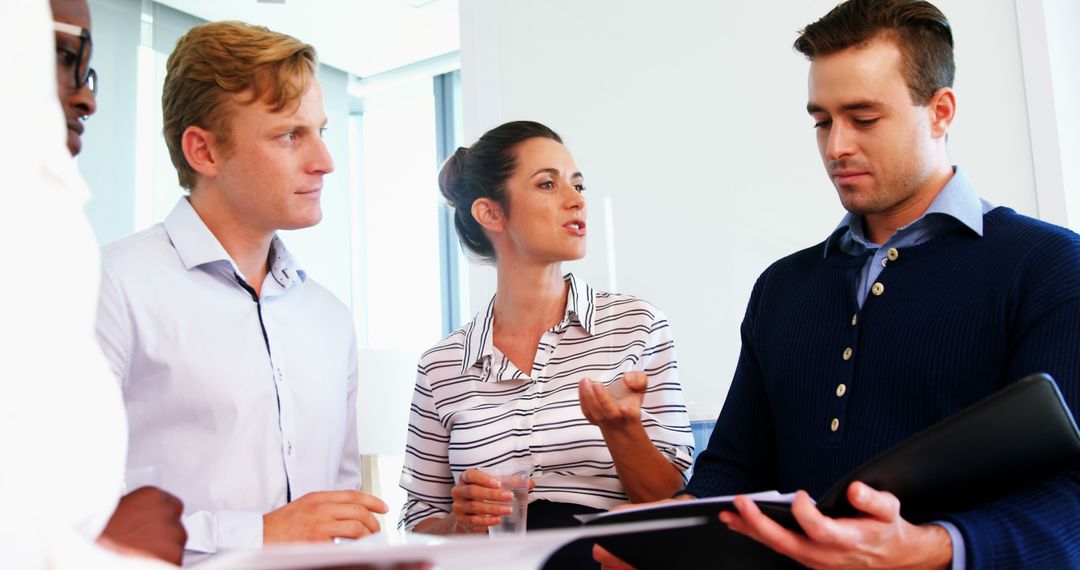 Executives Collaborating Over Documents in Modern Office Environment