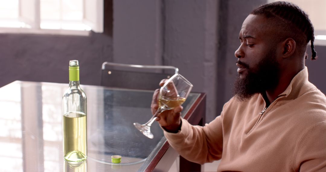 Man Enjoys Glass of White Wine at Modern Dining Table