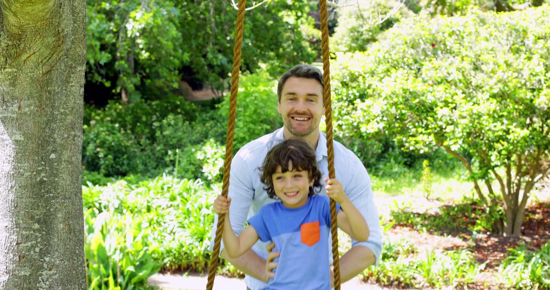 Father pushing his young son on a swing on a sunny day - Free Images, Stock Photos and Pictures on Pikwizard.com