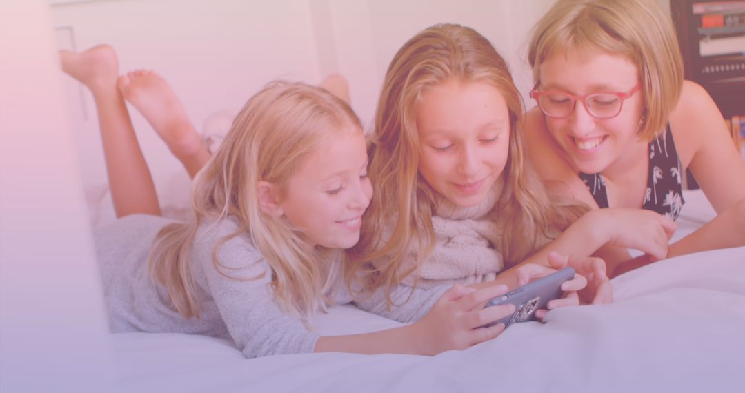Sisters Sharing Fun Moment Using Smartphone Together on Bed