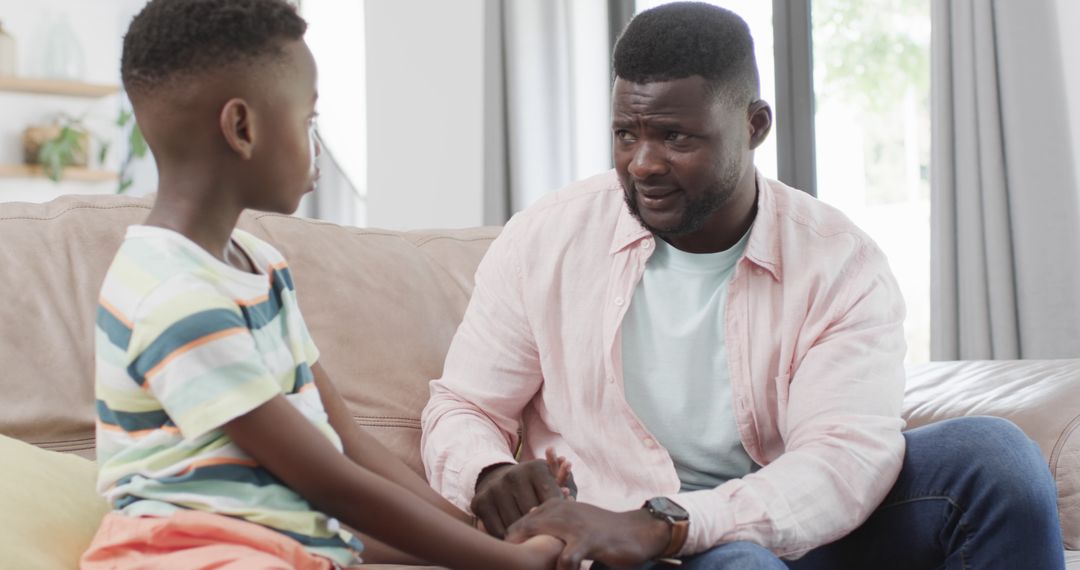 African American Father and Son Sharing a Serious Conversation at Home