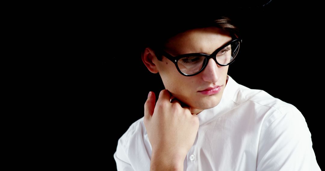 Stylish Young Man in Glasses and White Shirt Looking Away Thoughtfully - Free Images, Stock Photos and Pictures on Pikwizard.com