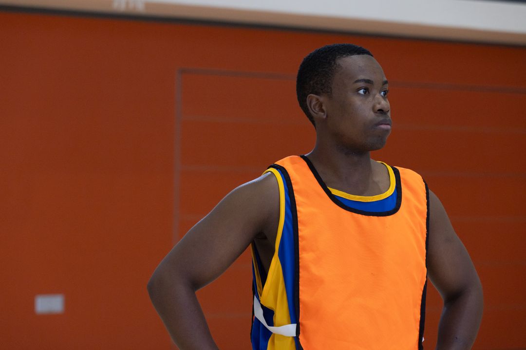 Focused Basketball Player in Gym Wearing Training Bib