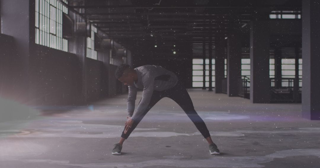 Man Stretching in Abandoned Warehouse with Futuristic Lights