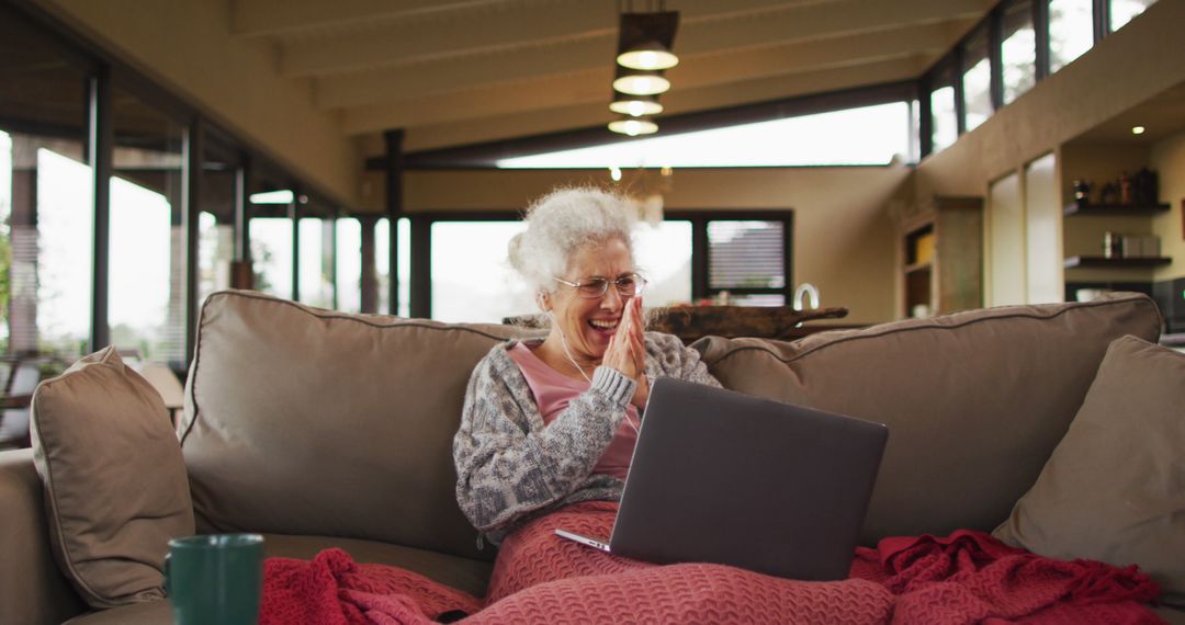 Cheerful Senior Woman Video Chatting with Family on Laptop in Modern Living Room - Free Images, Stock Photos and Pictures on Pikwizard.com