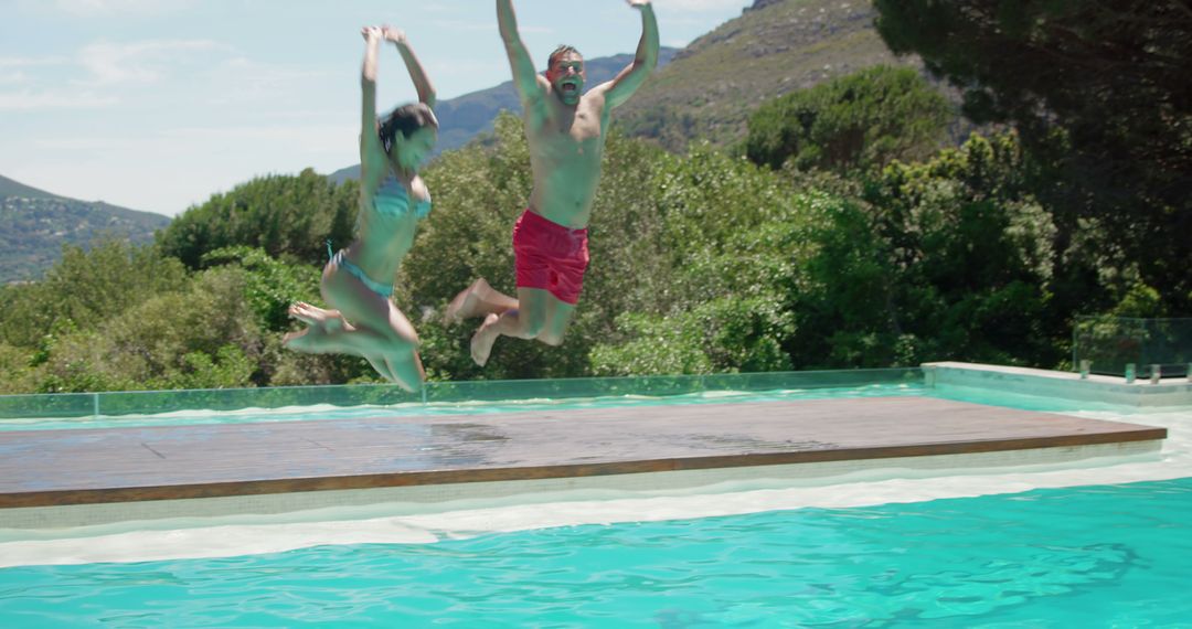 Couple Jumping into Swimming Pool on Sunny Day - Free Images, Stock Photos and Pictures on Pikwizard.com