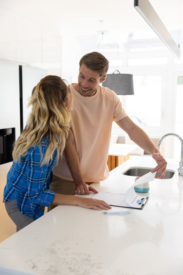 Couple Discussing Documents in Cozy Modern Kitchen