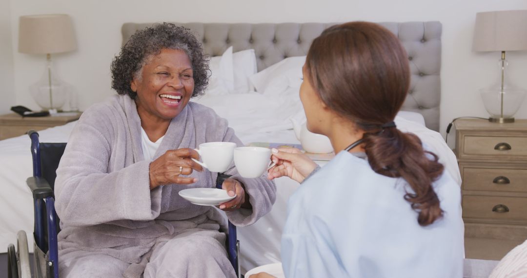 Happy Elderly Woman in Wheelchair Drinking Tea with Caregiver - Free Images, Stock Photos and Pictures on Pikwizard.com