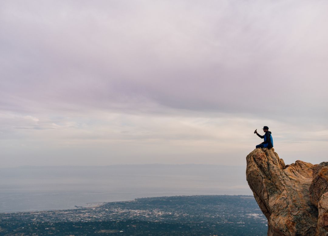 Person Hiking Stands on Mountain Cliff Edge Taking Selfie - Free Images, Stock Photos and Pictures on Pikwizard.com