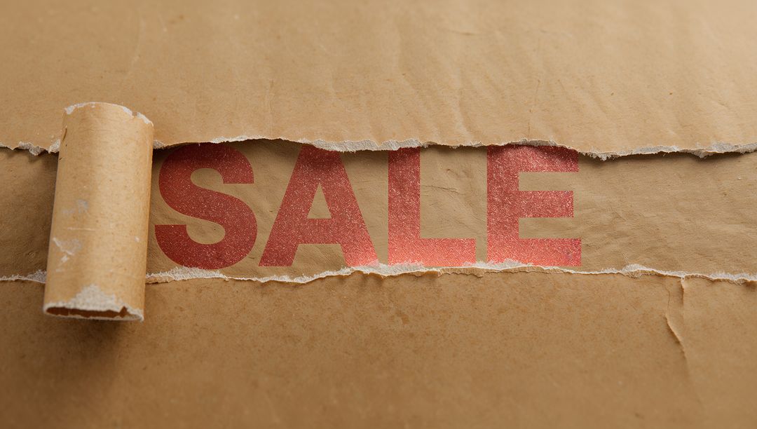 Kraft Paper Torn Reveal Showing Bold Red SALE Typography with Rolled Edge and Texture