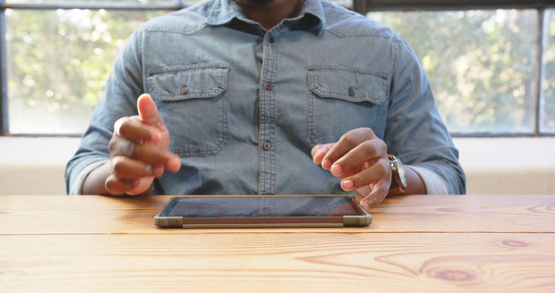 Man Using Tablet at Wooden Desk in Modern Office