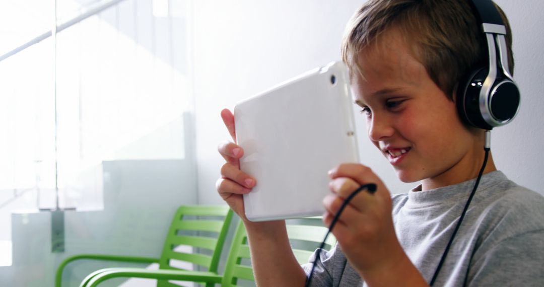 Happy Child Using Tablet with Headphones for Online Learning - Free Images, Stock Photos and Pictures on Pikwizard.com