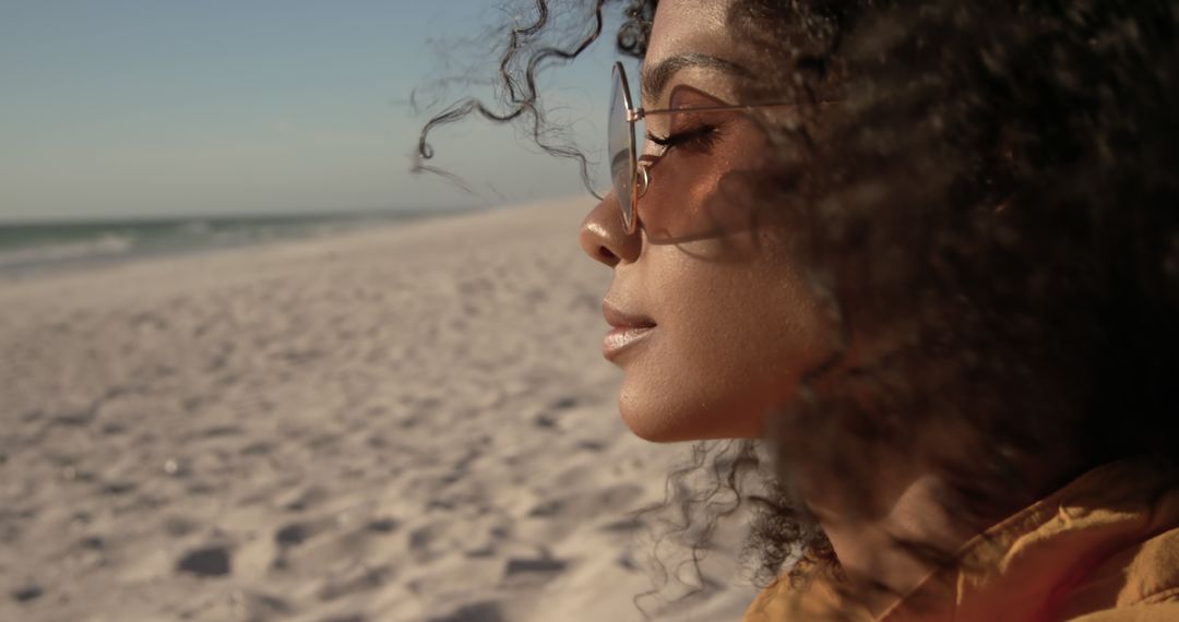 Relaxed Woman with Curly Hair Enjoying Sunset on Beach - Free Images, Stock Photos and Pictures on Pikwizard.com