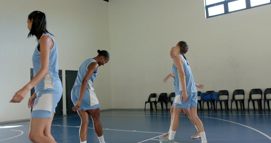 Female Basketball Team Warming Up in Gym Before Practice