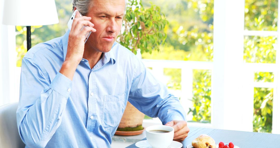 Businessman Having Breakfast and Talking on Mobile Phone - Free Images, Stock Photos and Pictures on Pikwizard.com