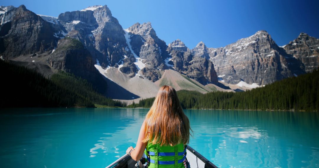 Woman Enjoying Scenic Mountain Lake in Canoe on a Sunny Day - Free Images, Stock Photos and Pictures on Pikwizard.com