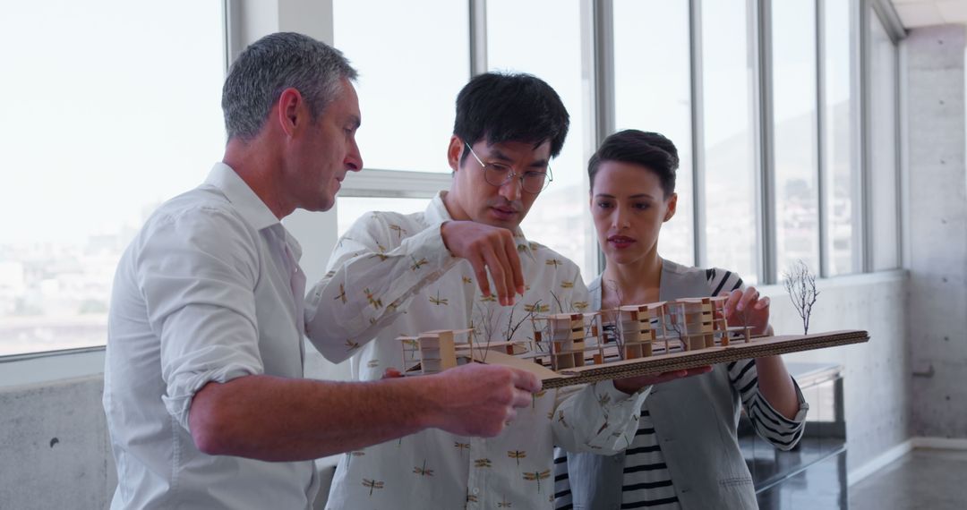 Diverse Architects Analyzing Factory Model in Contemporary Office