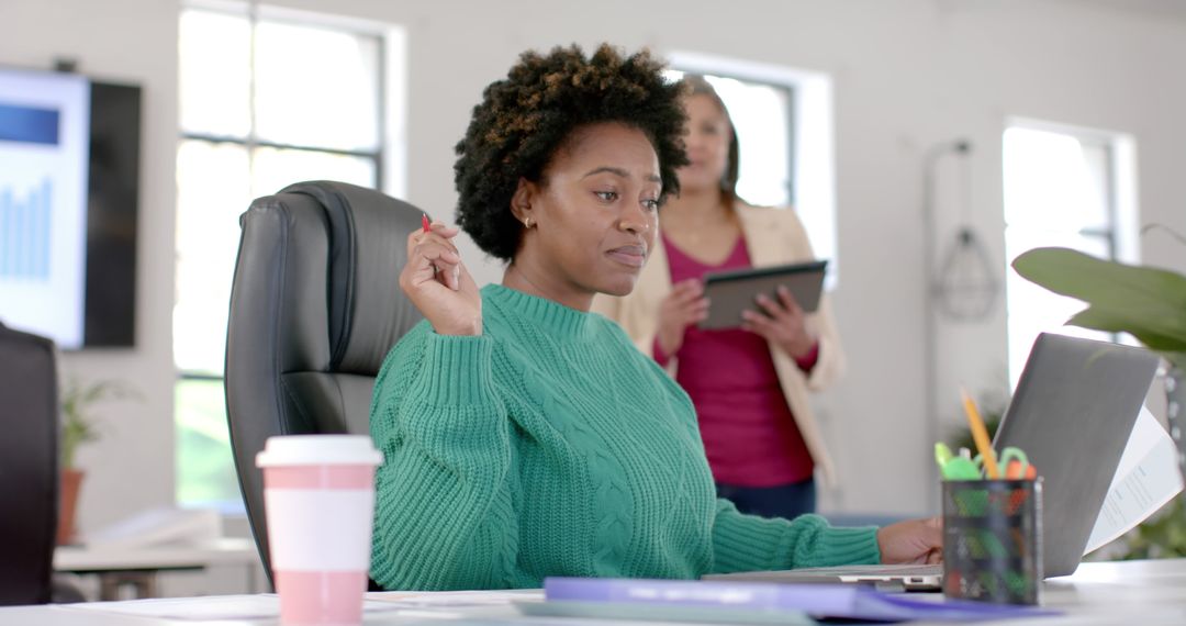 Focused Female Professional Analyzing Data on Laptop in Modern Office