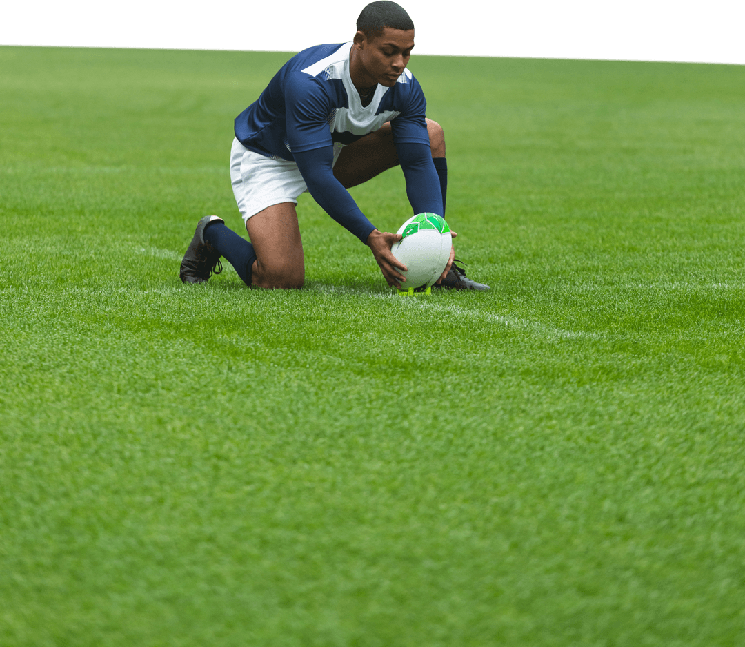 Male Rugby Player Kneeling on Field Placing Ball