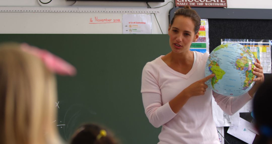 Female Teacher Explaining Geography Using Classroom Globe
