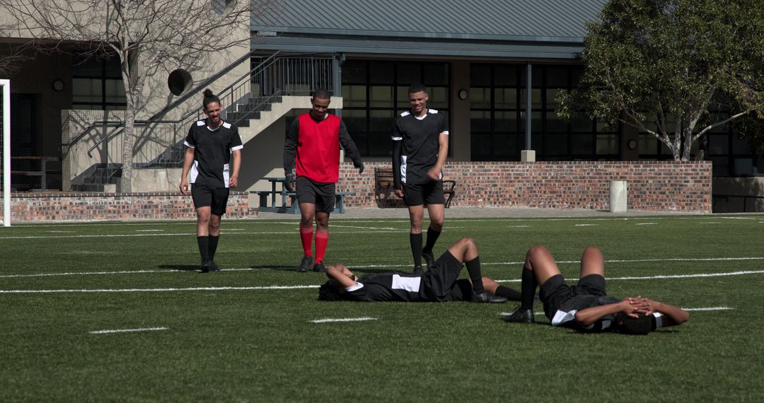 Soccer Players Resting and Discussing Strategy on Field