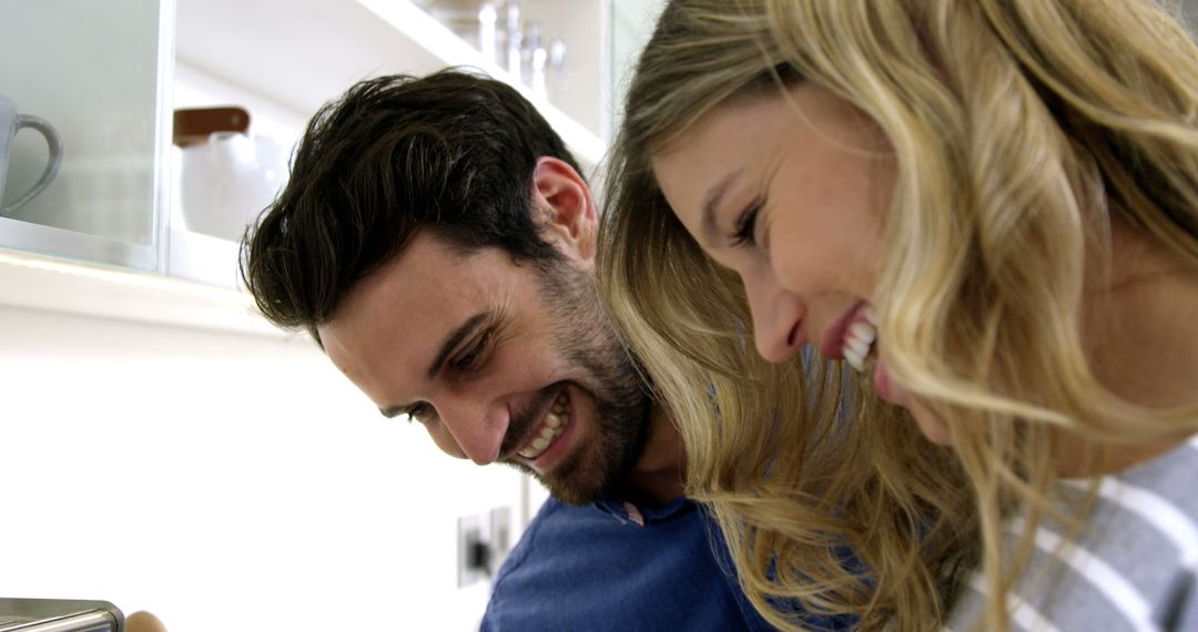 Happy Couple Laughing Joyfully in Kitchen Atmosphere
