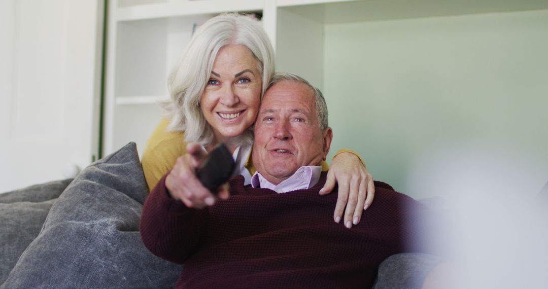 Happy Senior Couple Relaxing on Sofa Smiling Together