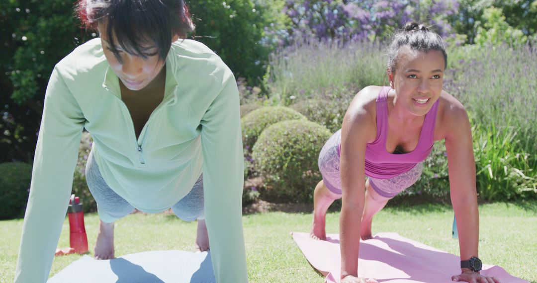 Two Women Practicing Outdoor Yoga in Sunlit Garden Setting - Free Images, Stock Photos and Pictures on Pikwizard.com