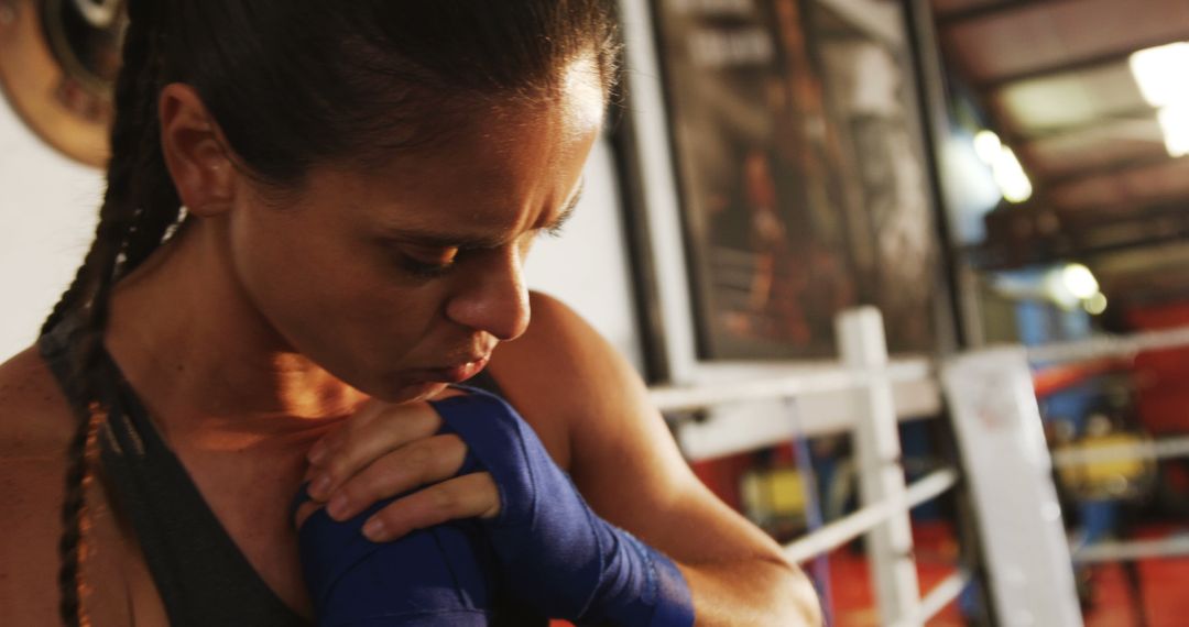 Focused Female Boxer Wrapping Hands in Training Gym - Free Images, Stock Photos and Pictures on Pikwizard.com