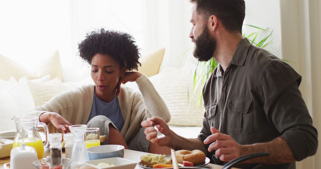 Diverse Couple Enjoying Breakfast and Conversation in Cozy Kitchen Setting