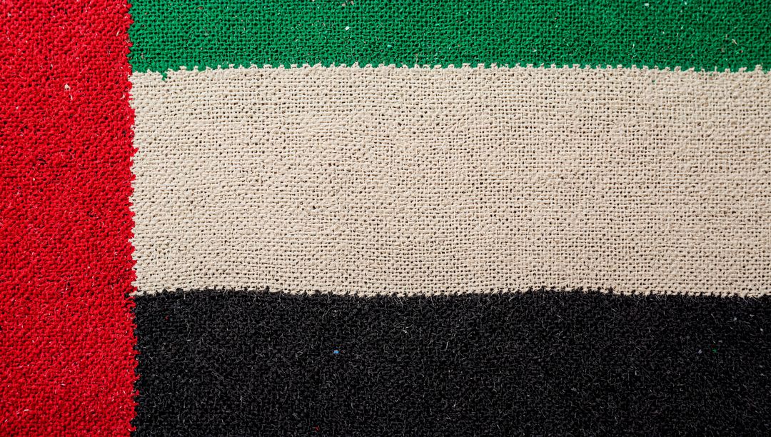 Displaying textured colorblock doormat with woven green beige black bands and red stripe