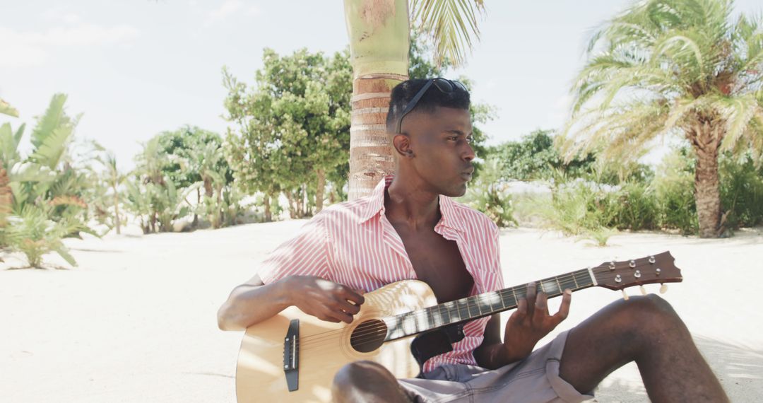 Man Playing Guitar on Tropical Beach - Free Images, Stock Photos and Pictures on Pikwizard.com