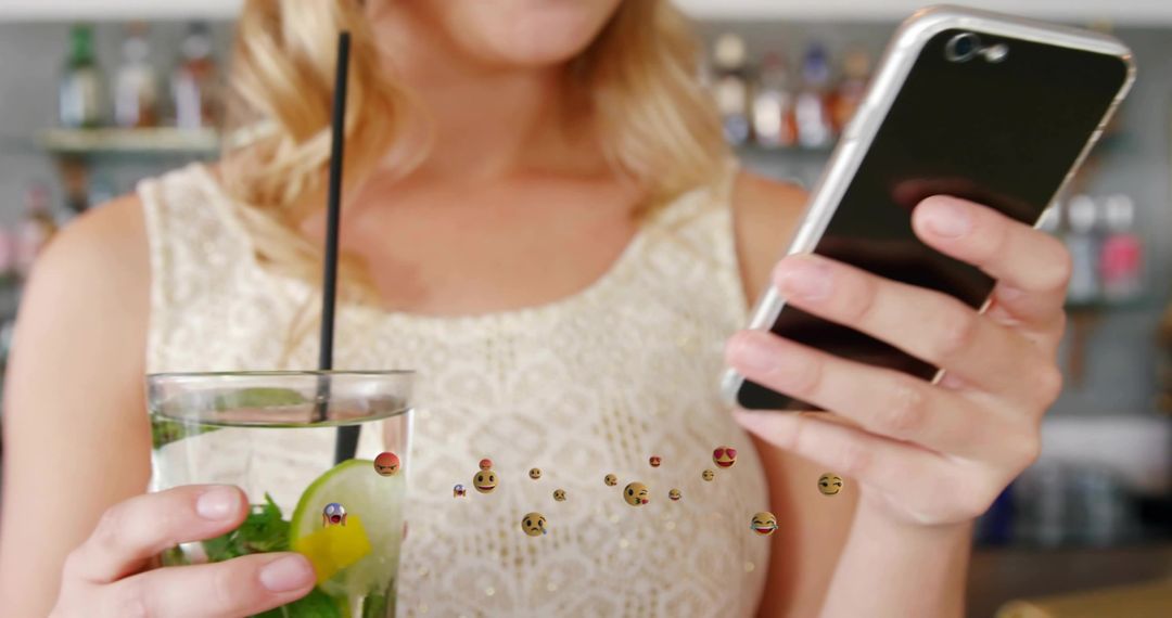 Woman Enjoying Cocktail While Messaging on Smartphone