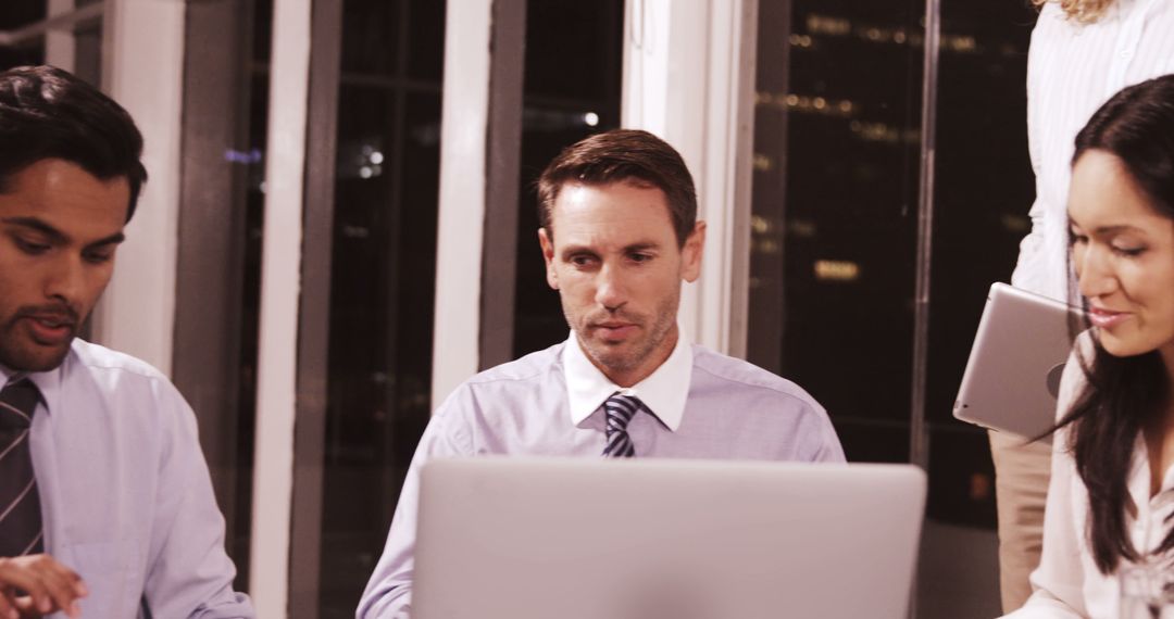 Diverse Team Collaborating in Office Environment at Night