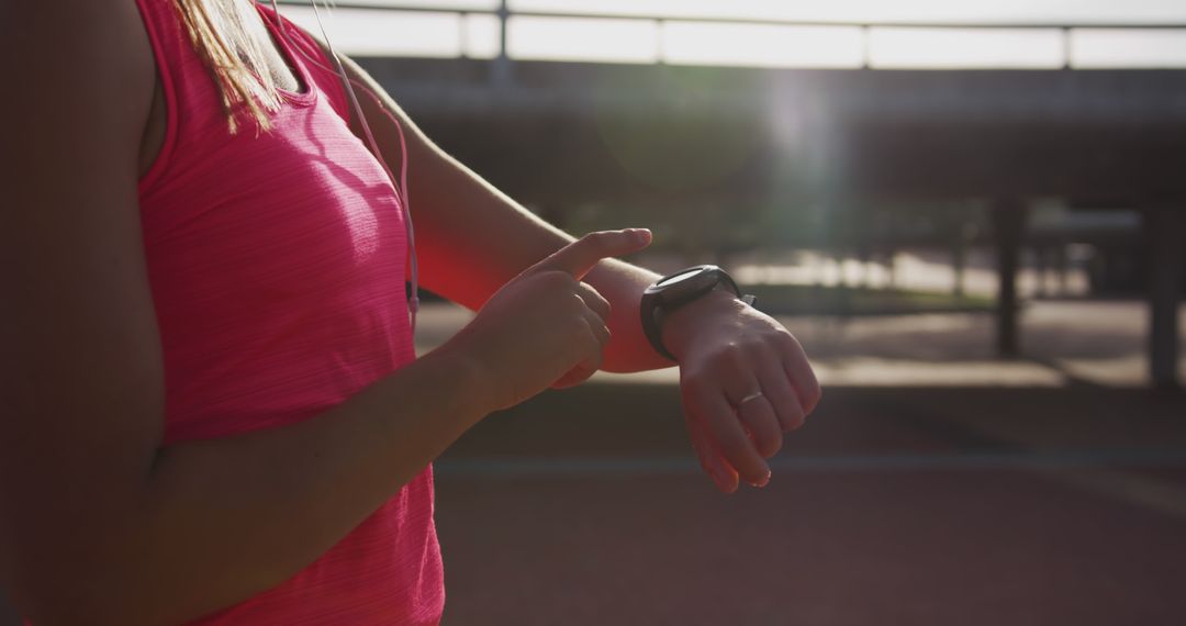 Woman Using Smartwatch While Exercising Outdoors in Sunlight - Free Images, Stock Photos and Pictures on Pikwizard.com