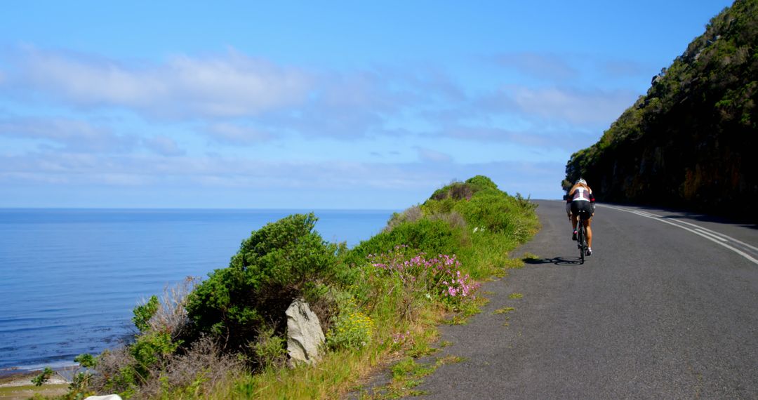 Cyclist Enjoying Scenic Ride Along Coastal Road - Free Images, Stock Photos and Pictures on Pikwizard.com