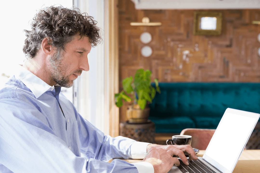 Focused Man Using Laptop at Cafe with Transparent Screen