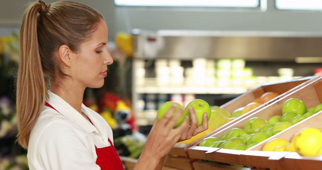 Shop Assistant Checking Fresh Apples at Grocery Store