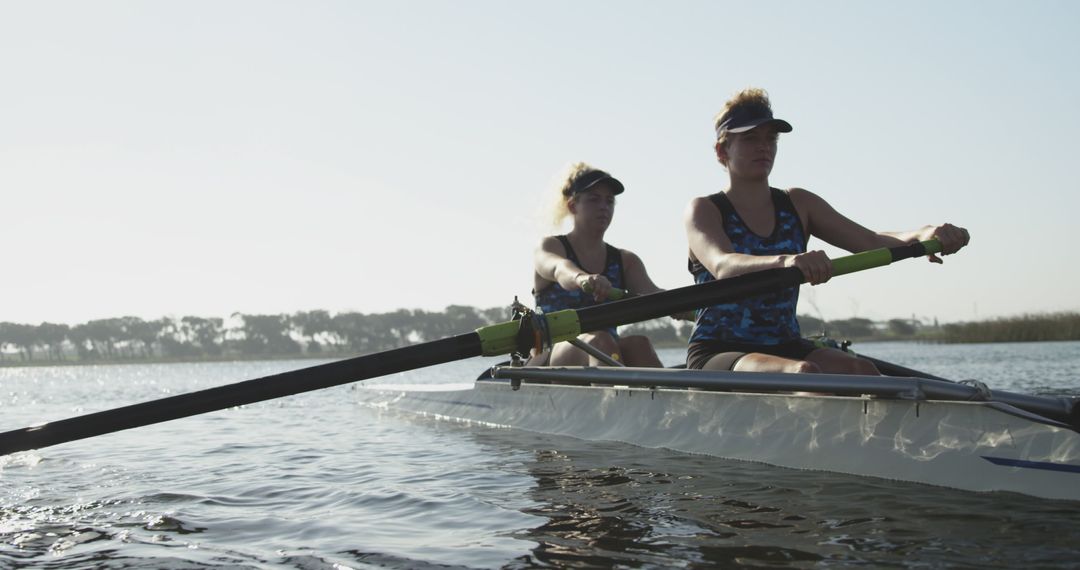 Two Female Athletes Rowing on Tranquil Lake in Morning Light - Free Images, Stock Photos and Pictures on Pikwizard.com