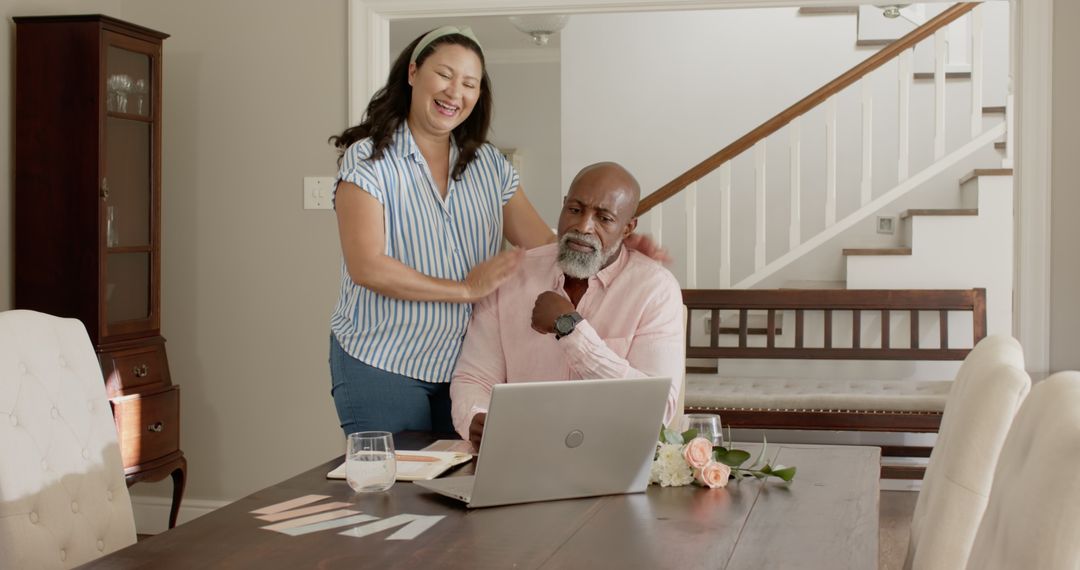 Smiling Couple Collaborating on Laptop in Bright Home Office