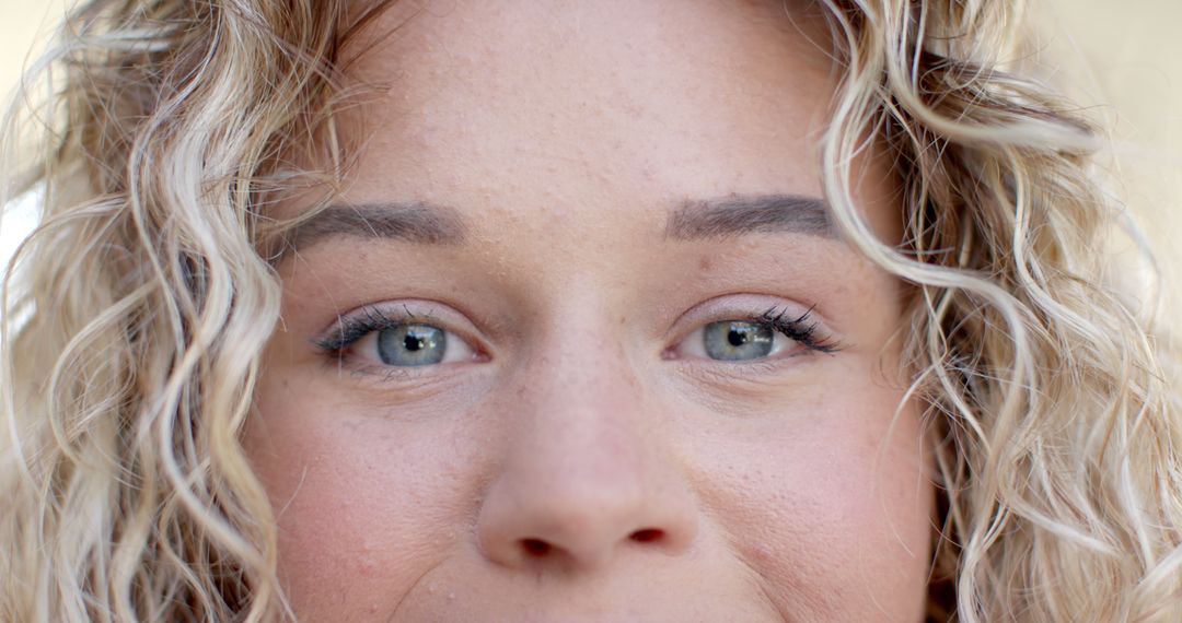 Close-Up of Young Woman's Face with Curly Hair and Natural Makeup - Free Images, Stock Photos and Pictures on Pikwizard.com