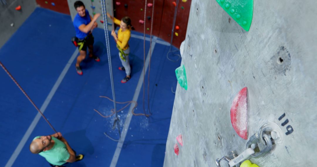 People Climbing and Belaying at Indoor Rock Climbing Gym - Free Images, Stock Photos and Pictures on Pikwizard.com