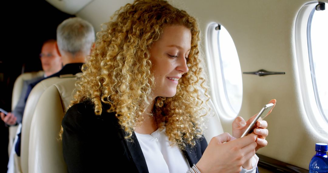 Young Woman Checking Phone in Luxury Airplane Cabin