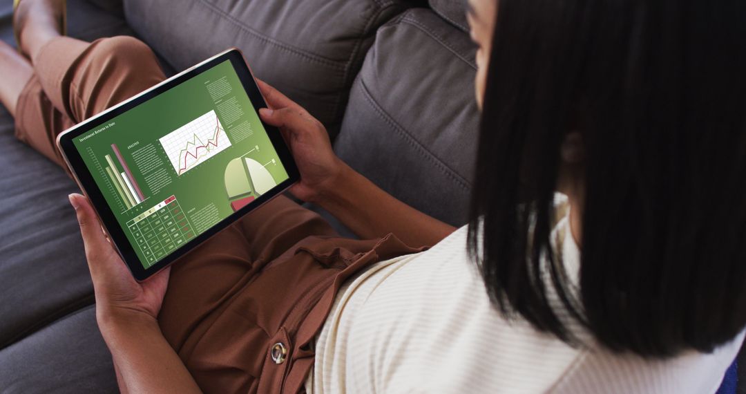 Biracial Woman Viewing Data Analytics on Tablet at Home