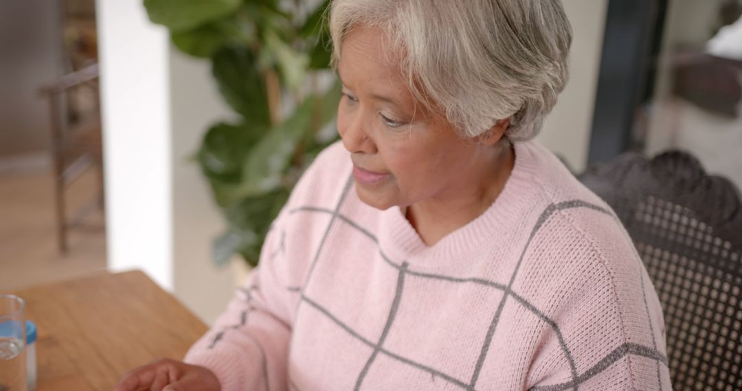 Elderly Woman Sitting at Table in Calm Home Environment - Free Images, Stock Photos and Pictures on Pikwizard.com