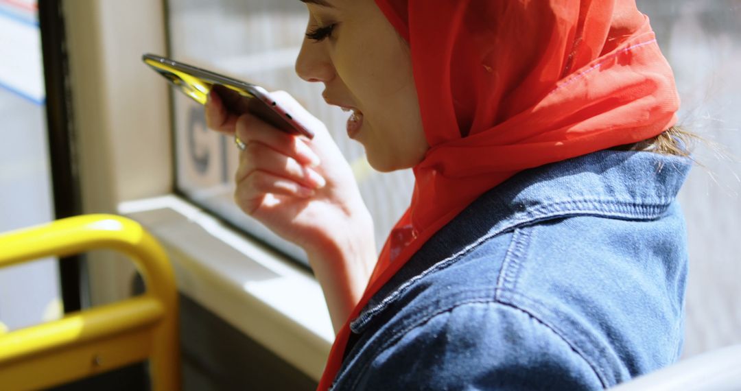 Muslim Woman in Red Hijab Using Smartphone Voice Assistant on Bus - Free Images, Stock Photos and Pictures on Pikwizard.com