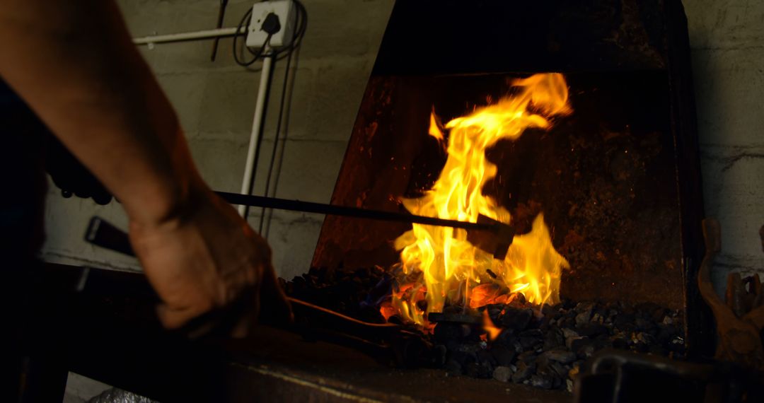 Blacksmith Forging Metal in Fiery Furnace Workshop - Free Images, Stock Photos and Pictures on Pikwizard.com