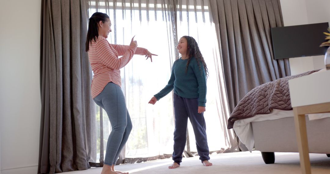 Mother and Daughter Laughing and Dancing in Bedroom - Free Images, Stock Photos and Pictures on Pikwizard.com