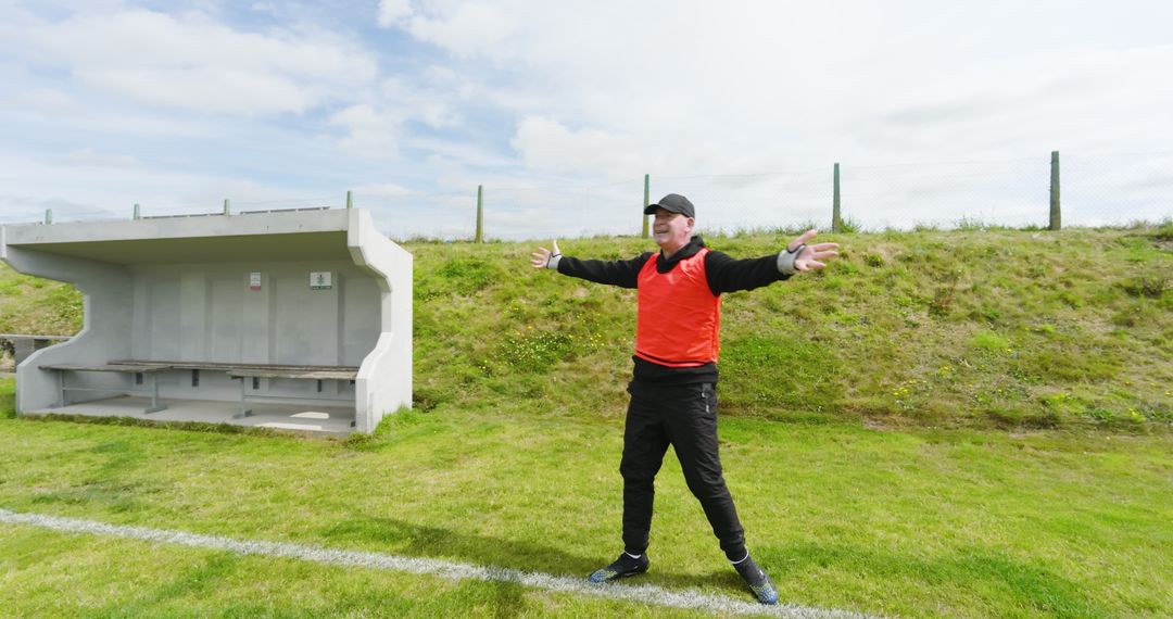 Football coach on outdoor pitch with dugout