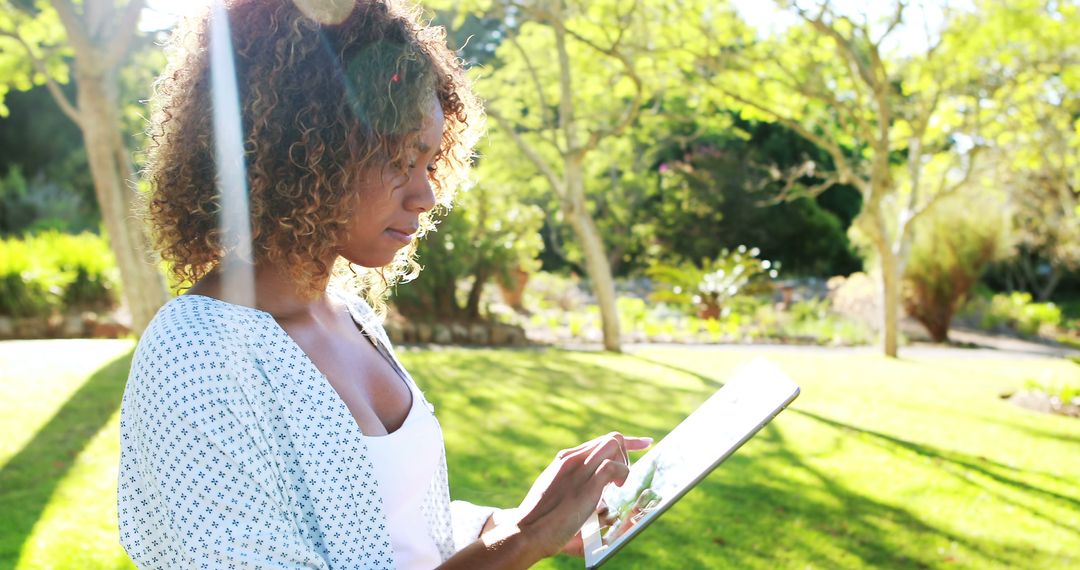 Woman using digital tablet in park on a sunny day 4k - Free Images, Stock Photos and Pictures on Pikwizard.com